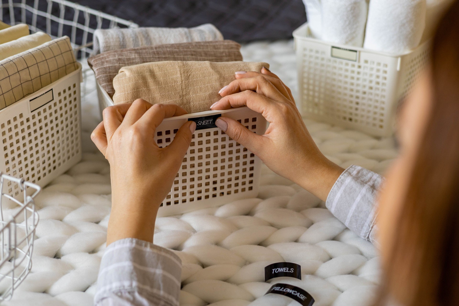Woman hands neatly folded linens and towels use modern method with sticky label tags